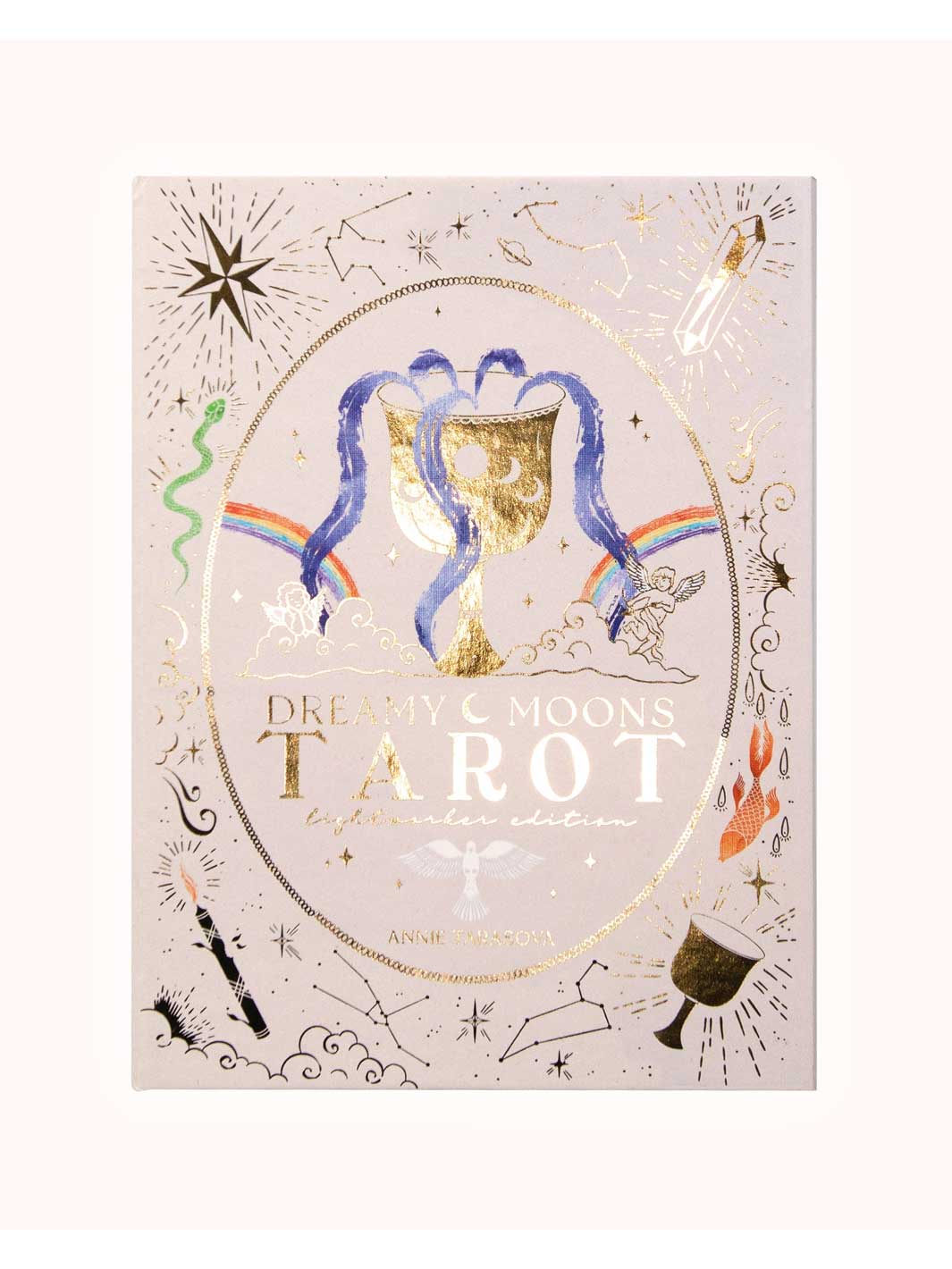 Dreamy Moons Tarot: Lunar Eclipse edition card deck box, featuring a light pink background with gold foil celestial illustrations, a gold chalice, and blue hair-like strands.
