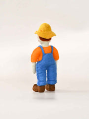 Felt toy resembling a farmer Old McDonald character in an orange shirt, blue overalls, and yellow hat on a white background