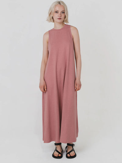 Woman wearing a long pink dress on a white background