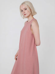 Woman wearing a pink sleeveless maxi dress against a white background