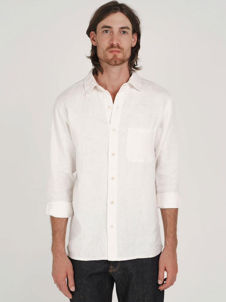 Man wearing a white hemp button-up shirt with plastic-free buttons against a plain background