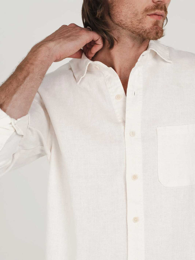 Man wearing a white hemp clothing Australia button-up shirt with plastic-free buttons against a plain background