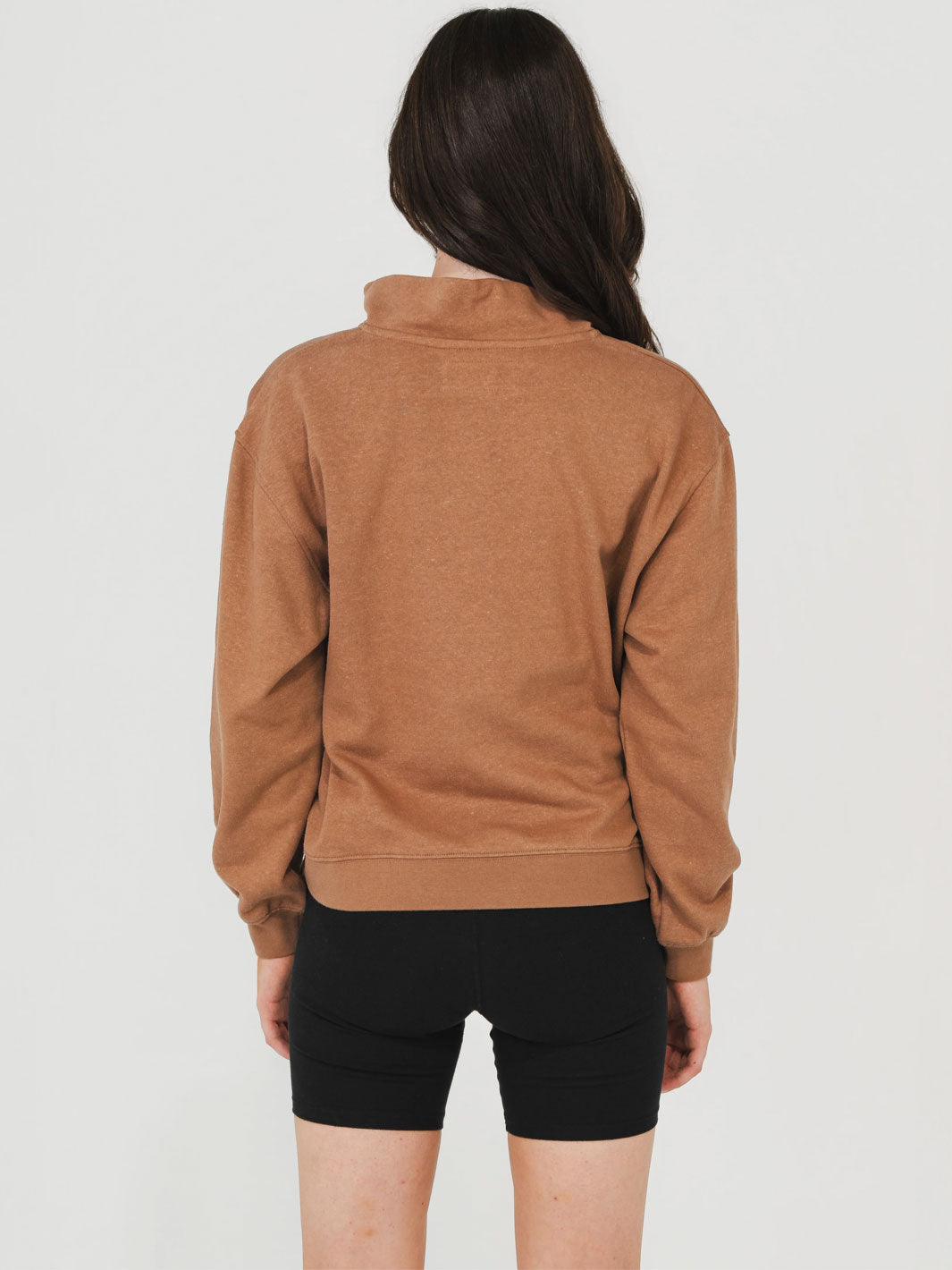 Person wearing a brown fleece jacket on a plain background