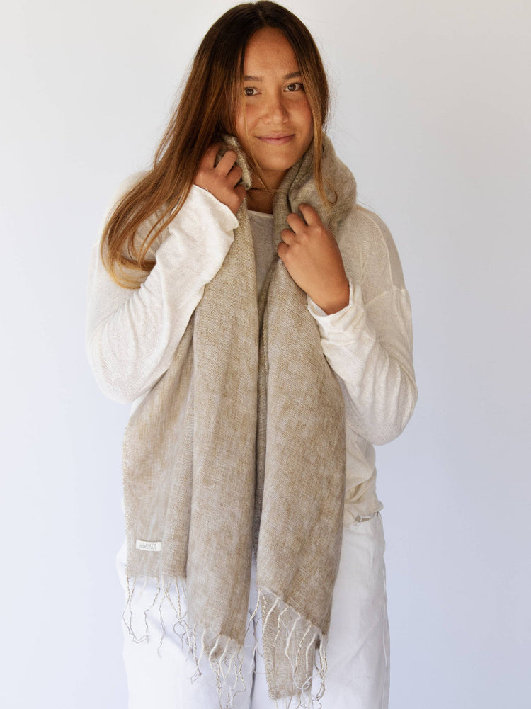 Woman wearing a beige scarf against a white background