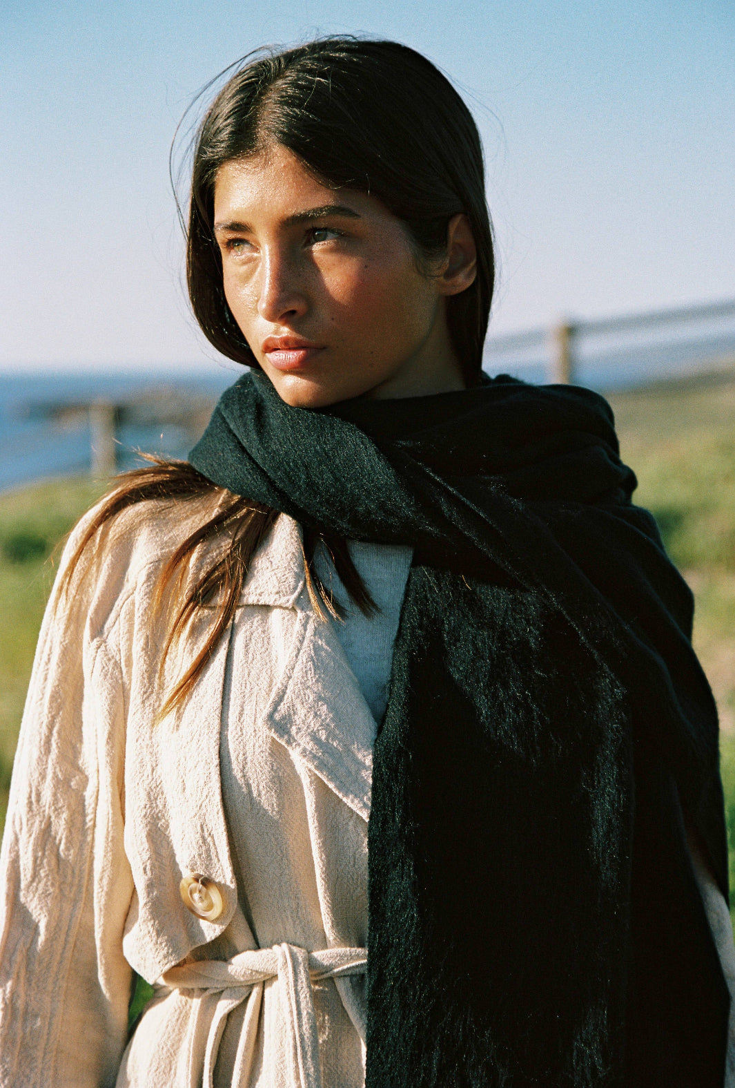 Woman wearing a black scarf in a scenic outdoor setting