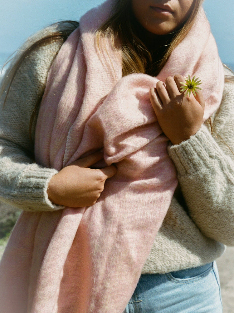 Person wearing a pink scarf with a blurred background