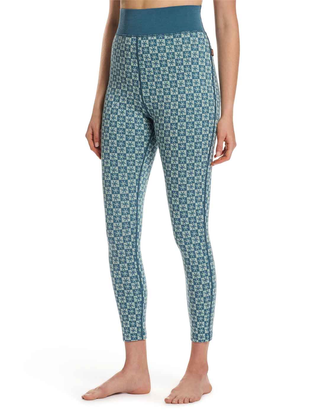 A model wearing high-waisted thermal leggings with a blue and white geometric pattern, shown from the waist down against a plain white background.