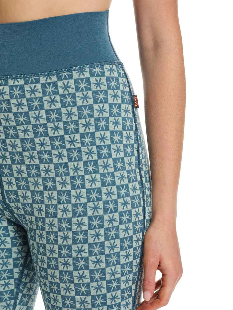 Close-up of a person wearing high-waisted leggings with a blue and white geometric star pattern and a solid blue waistband.
