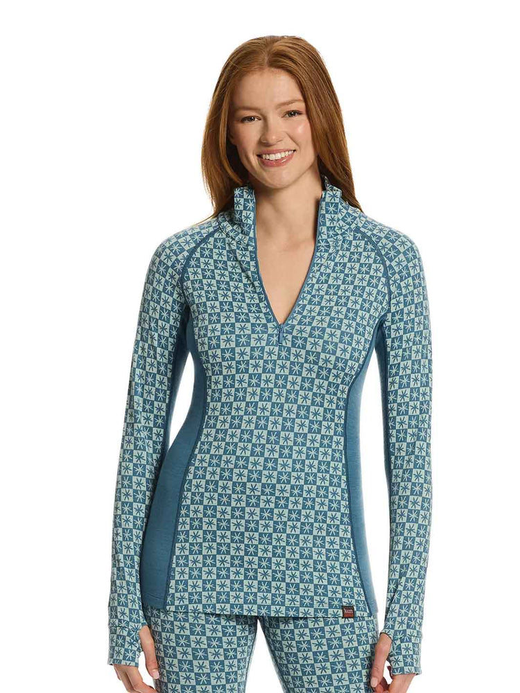 A smiling woman with red hair wearing a matching long-sleeve patterned top and pants set in a blue and white geometric design, photographed against a solid white background.