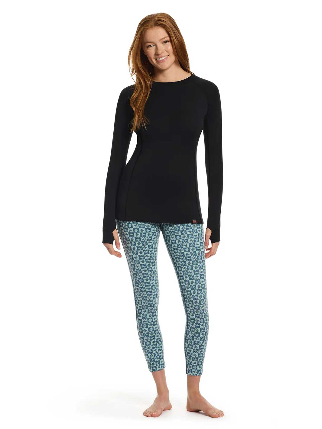 A woman modeling a black long-sleeve top and blue geometric patterned leggings against a plain white background.