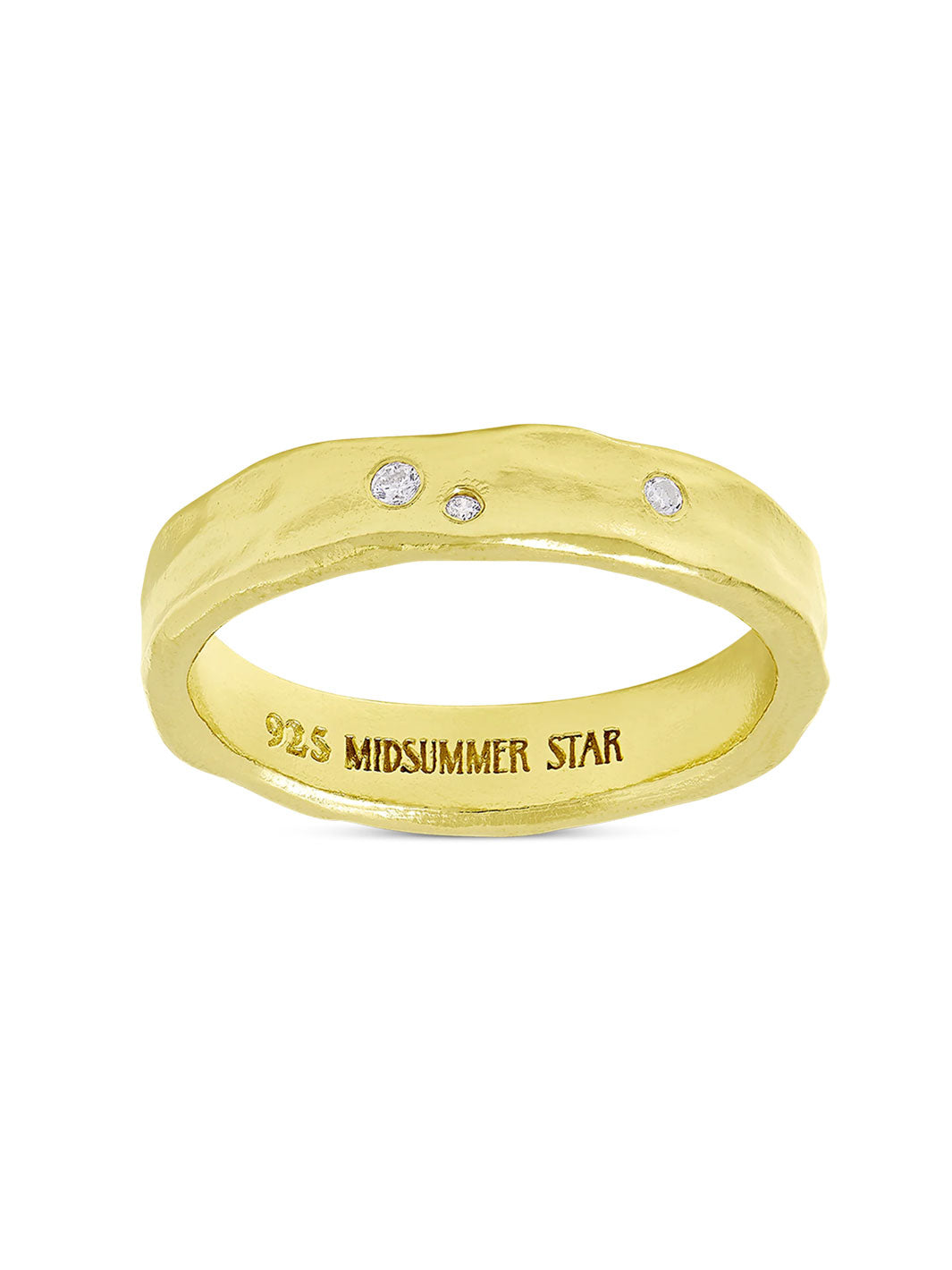 A yellow gold ring with a wavy, organic shape and three small clear stones set across the top. The inside of the band is engraved with &