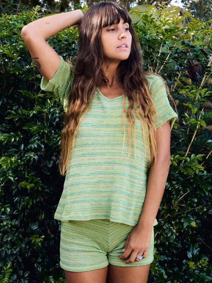 Woman wearing a green striped baby tee in hand dyed cotton. Made in Australia
