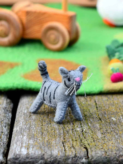 Gray cat toy on a wooden surface with a colorful background