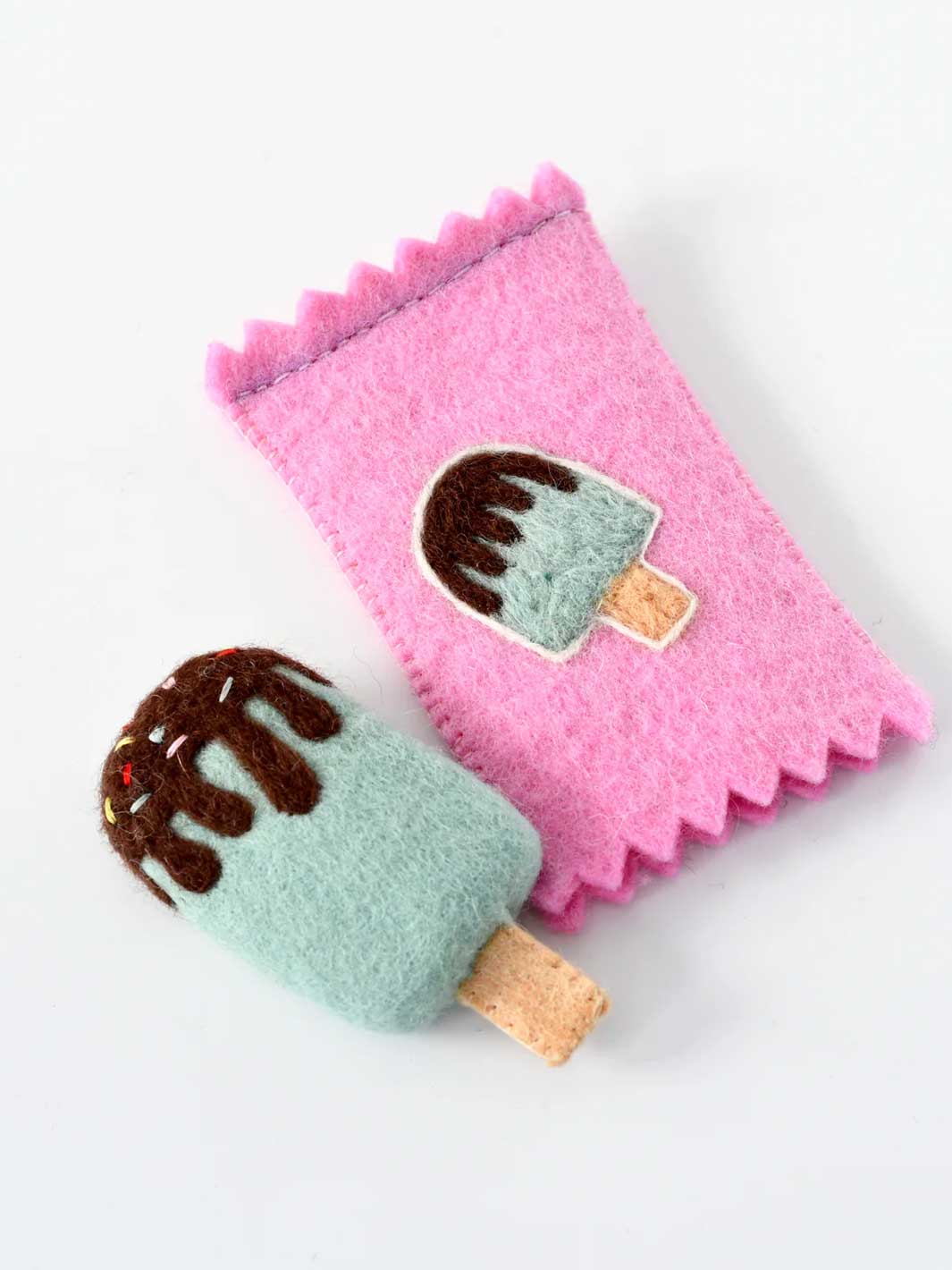 A pink felt ice cream cone pouch with a matching felt ice cream cone accessory, both featuring a mint green body, brown chocolate drizzle, and a cork-colored wooden stick, set against a plain white background.
