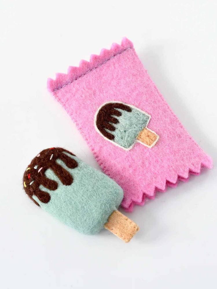 A pink felt ice cream cone pouch with a matching felt ice cream cone accessory, both featuring a mint green body, brown chocolate drizzle, and a cork-colored wooden stick, set against a plain white background.