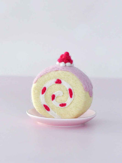 Felt toy resembling a swiss roll with pink and white swirl on a light gray background