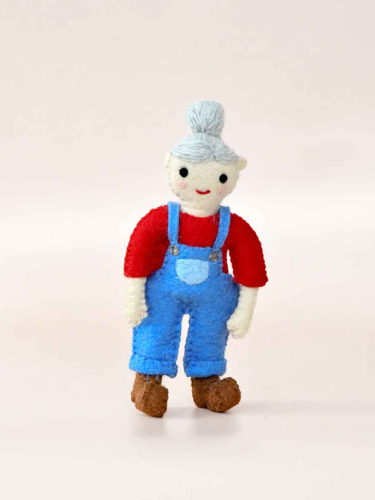 Felt toy figure wearing a red shirt, blue overalls, and a gray hat on a light background. Female Farmer
