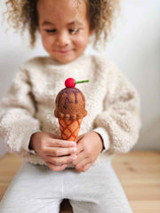 Child holding a felt toy ice cream cone with a cherry on top