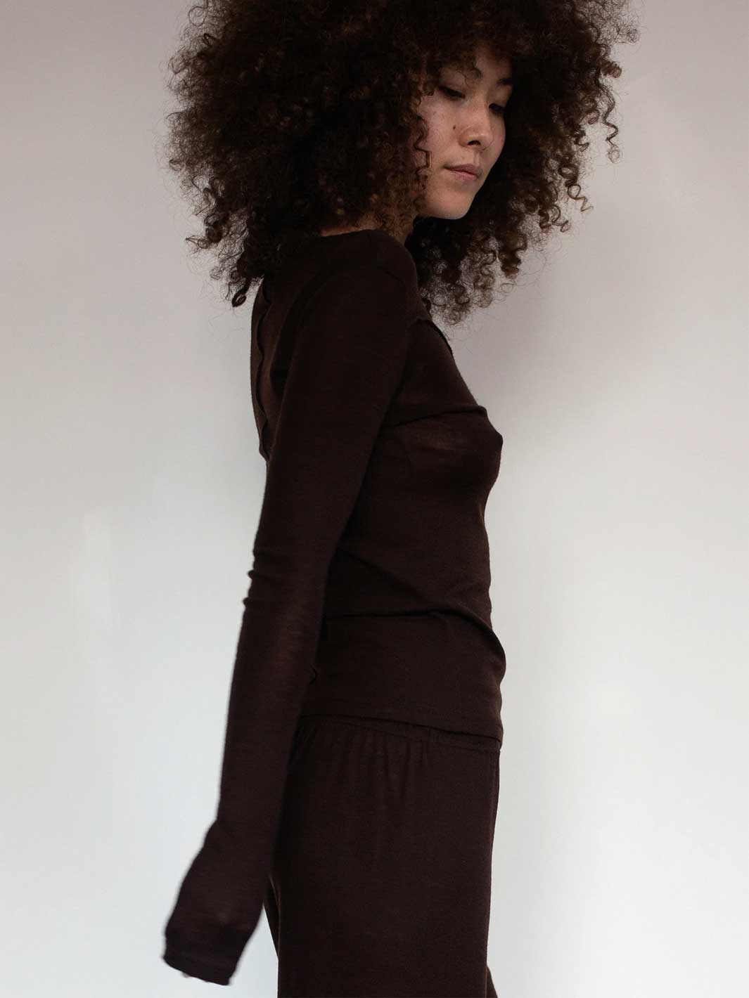 Person wearing a brown outfit against a plain background