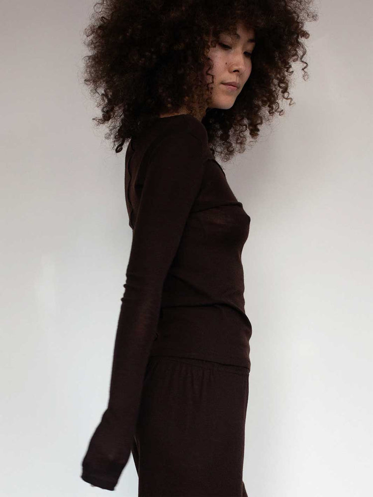 Person wearing a brown outfit against a plain background