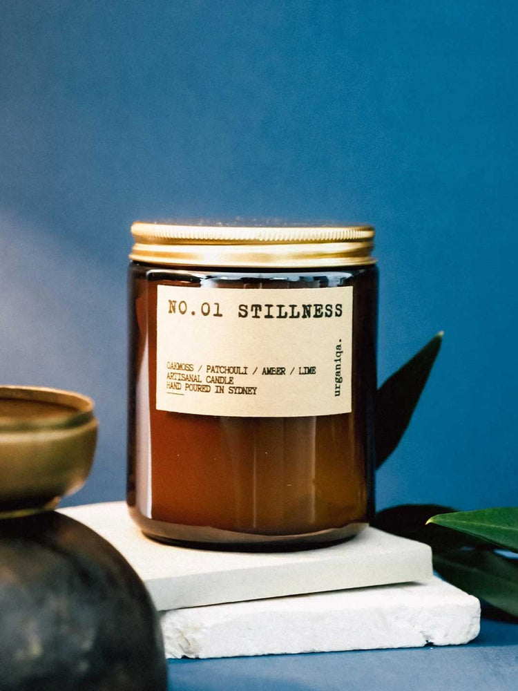 Candle labeled 'No. 01 Stillness' on a blue background