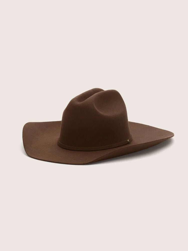 A classic brown felt cowboy hat with a wide brim and a pinched crown, displayed on a solid light beige background.