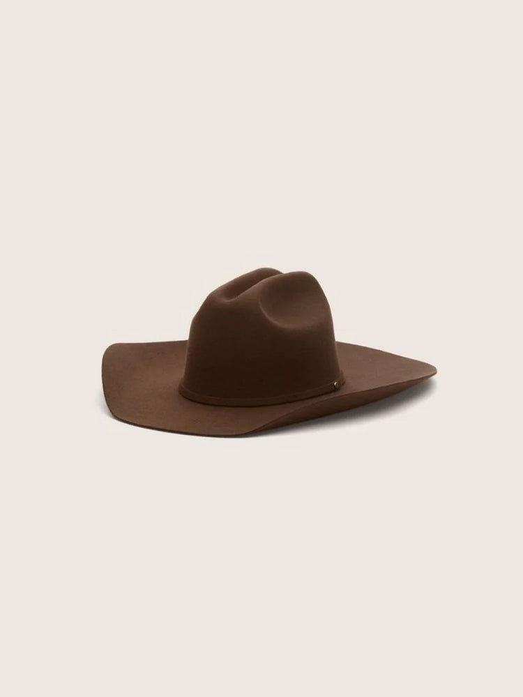 A dark brown felt kids cowboy hat with a wide brim, photographed from a side profile against a solid light beige background.